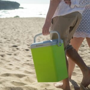 A couple walks along a sunny beach in Portugal carrying a cooler.